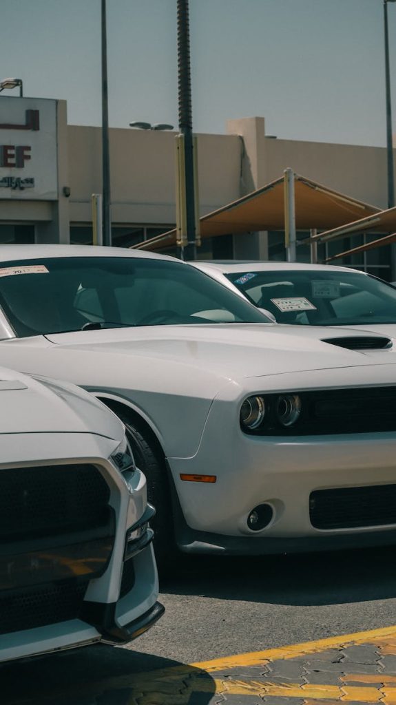 front-of-white-dodge-challenger-on-car-dealership-lot-25286589 White Dodge Challenger in a car dealership parking lot during the day.